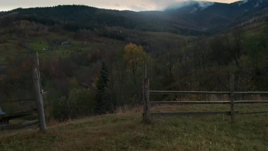 A guy goes out to the expanse of mountains and looks into the distance. Authentic look of a mountain village