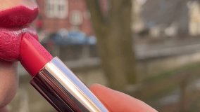 A captivating video featuring a young woman skillfully applying lipstick, enhancing her lips with precision and artistry. 