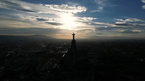 Silhouette of the Christ of Monteagudo, Murcia. Statue simulating a Christian cross. In the background the sky at sunset. Vertical drone video