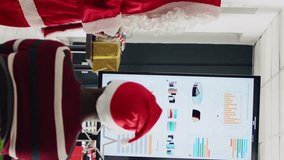 Vertical video Experienced speaker dressed as Santa Claus doing presentation in front of company workers using candy cane pointer. Employees learning how to advance their career during Christmas - Powered by Shutterstock - Get 15% off with code: PIKWIZARD15