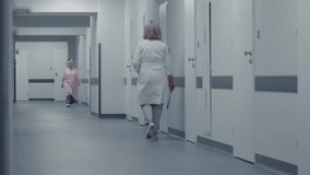 Doctors and nurses run and push gurney with seriously injured patient to operating room. Professional medics save human life in emergency department. Medical facility hallway. Back view. Slow motion. - Powered by Shutterstock - Get 15% off with code: PIKWIZARD15