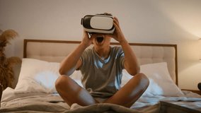 Surprised amazed Caucasian child kid boy playing video game using innovative digital VR headset on bed home play online 3d AR technology in metaverse world wearing wireless virtual reality glasses - Powered by Shutterstock - Get 15% off with code: PIKWIZARD15