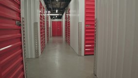 Dolly shot of corridor in self storage building with red locked doors of units, no people there - Powered by Shutterstock - Get 15% off with code: PIKWIZARD15