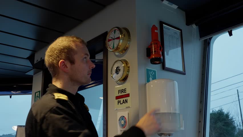 Ships Captain testing emergency radar transponder SART, wheelhouse