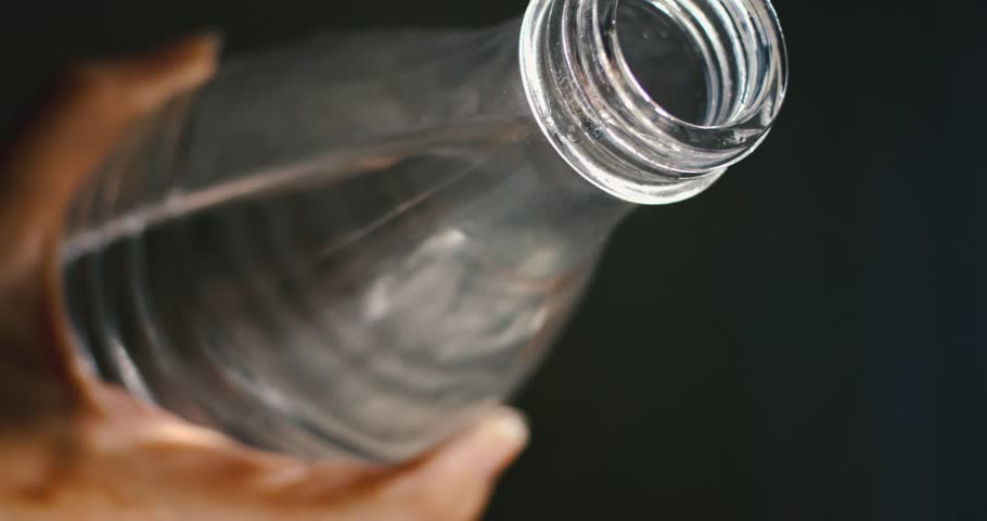 male hand pouring a wonderful lookingstream of water out of glass bottle, stay healthy, hydrate, slowmotion, highspeed