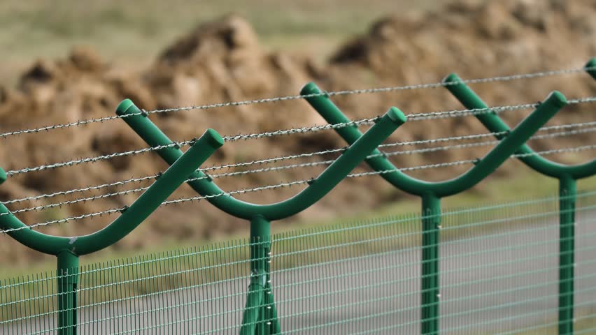 vue rapprochée du fil de fer barbelé sur une clôture en béton