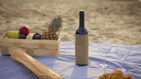 Wicker basket, red wine bottle and glasses on blanket with fresh ripe fruits on ocean sand beach during picnic in fresh air. Party outdoors. Enjoying time together concept - Powered by Shutterstock - Get 15% off with code: PIKWIZARD15