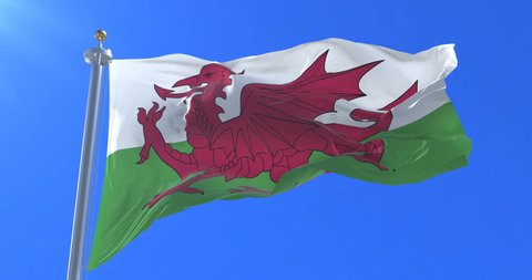 Flag of Wales waving at wind in slow with blue sky, loop