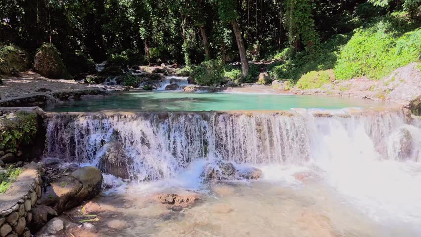 Birdseye view of Villa Miriam private residence with swimming pools and natural waterfalls, San Rafael , province of Barahona in Dominican Republic. Aerial drone forward