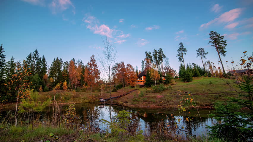 Wooden forest home with lake nearby, motion time lapse view