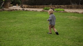A child running merrily across the villa's green lawn grass. Happy video