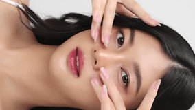 Close up face of young beautiful young Asian woman with healthy and fresh skin. Vertical beauty footage.