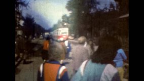Tram move to people crowd in summer street. Passengers preparing to board city electric transport. Public railway transport stop. Urban transportation. Vintage color archive film. Retro, 1980s Russia