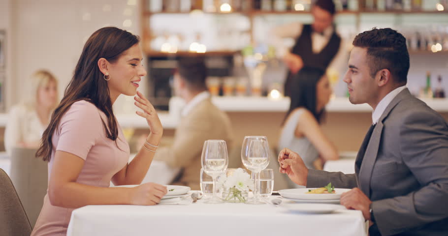 Happy couple on date in restaurant with wine, holding hands and romantic evening together with fine dining service. Love, man and woman relax in luxury diner with smile, drinks and valentines day Royalty-Free Stock Footage #3405037525