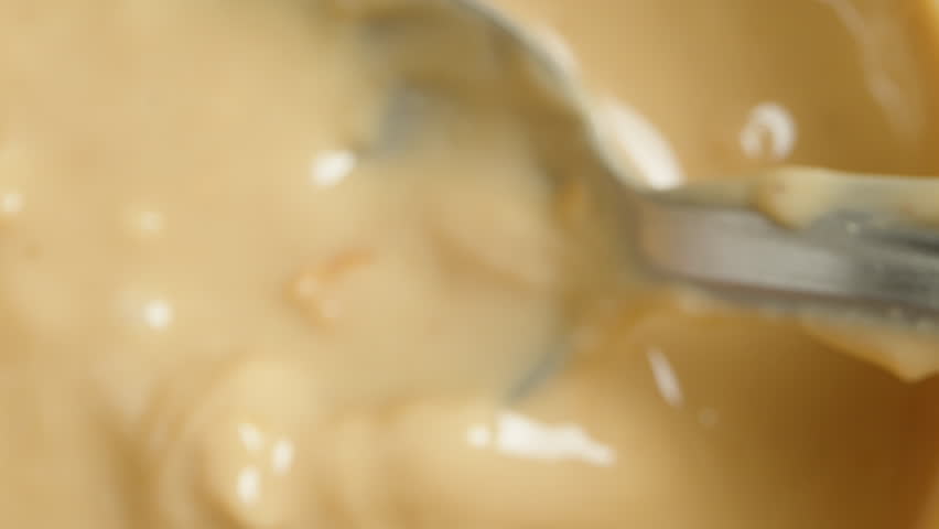 Stirring Peanut Butter with Nut Pieces, Spoon in Close-Up. Dolly slider Royalty-Free Stock Footage #3405049559