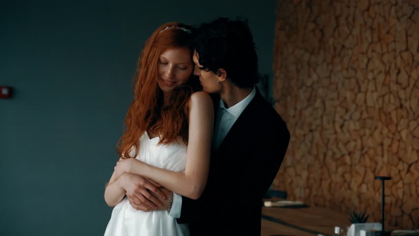 Fairy-tale wedding couple posing in a stylish house with panoramic windows and mountain views. Red-haired bride posing with the groom. Wedding concept Royalty-Free Stock Footage #3405104521