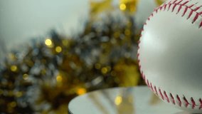 Cinematic slow close-up shot of a white base ball, red stitches baseball on a shiny stand, Christmas blurry decorations in the background, professional studio lighting, 4K video pan right