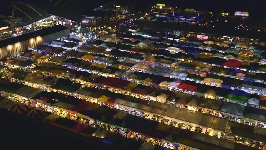 Close-up panning of rows of colorful outdoor market tents and food stalls at night. Fairs, marketplaces, shopping, dining outdoors, Asian markets, local traditions, tourist trapsor attractions