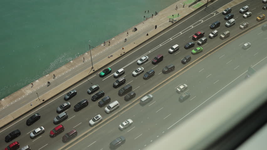 Top view of road, blurred cars, boat and yachts, azure water. Highway with car traffic near the sea  