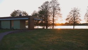 Modern minimalist architecture of a small house by the lake captured at golden hour with a pathway leading to it - Powered by Shutterstock - Get 15% off with code: PIKWIZARD15