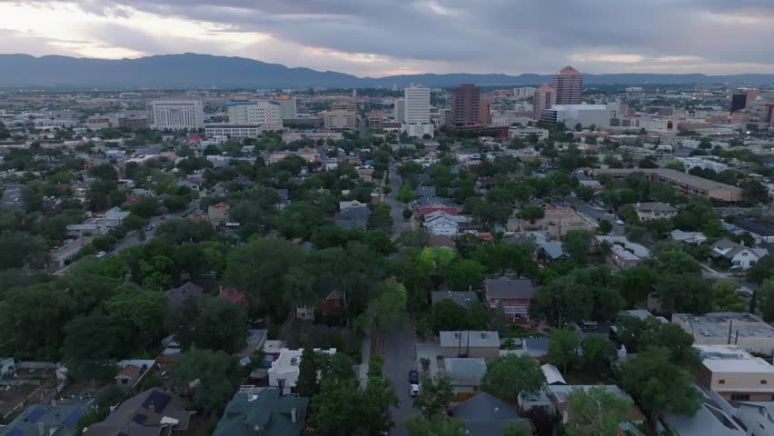 Wide panoramic view of Albuquerque, New Mexico skyline and housing. Aerial reveal during sunrise.
