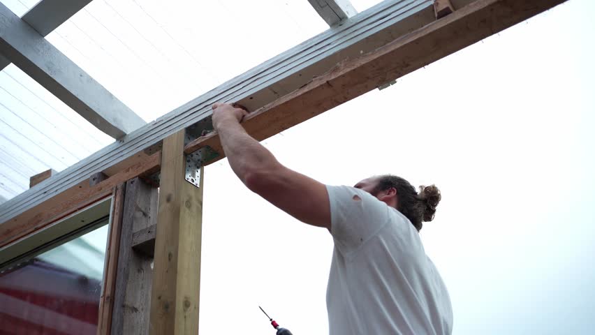 A Man is Building the Framework for a Greenhouse in Indre Fosen, Trondelag County, Norway - Close Up