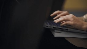 close-up of a young businesswoman busy working on a laptop or computer keyboard to send emails and surf on a web browser. female hands typing on thin laptop keyboard, close up. horizontal video