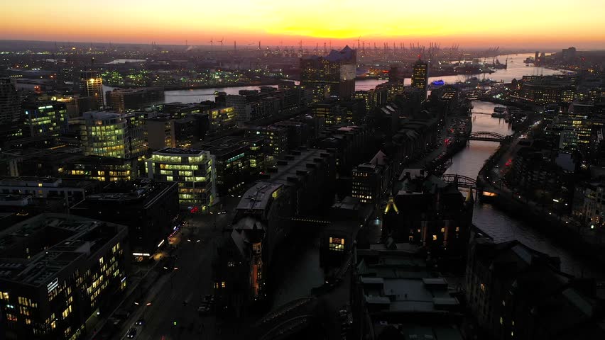 4К Aerial Drone View of HafenCity at sunset, Hamburg, Hanseatic City. City lit up at night, downtown Hamburg, Germany Night city landscape. Amazing rising above cityscape in Hamburg city center