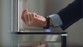 Hand with smartwatch touching sensor control panel unlocking office turnstile close up. Unrecognizable businessman using digital watch passing identification security control in business center. - Powered by Shutterstock - Get 15% off with code: PIKWIZARD15