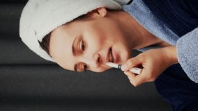 Woman applying lipstick on lips and looking at mirror. Cute charming female in blue bathrobe paints lips at home. Health and beauty. Vertical video - Powered by Shutterstock - Get 15% off with code: PIKWIZARD15