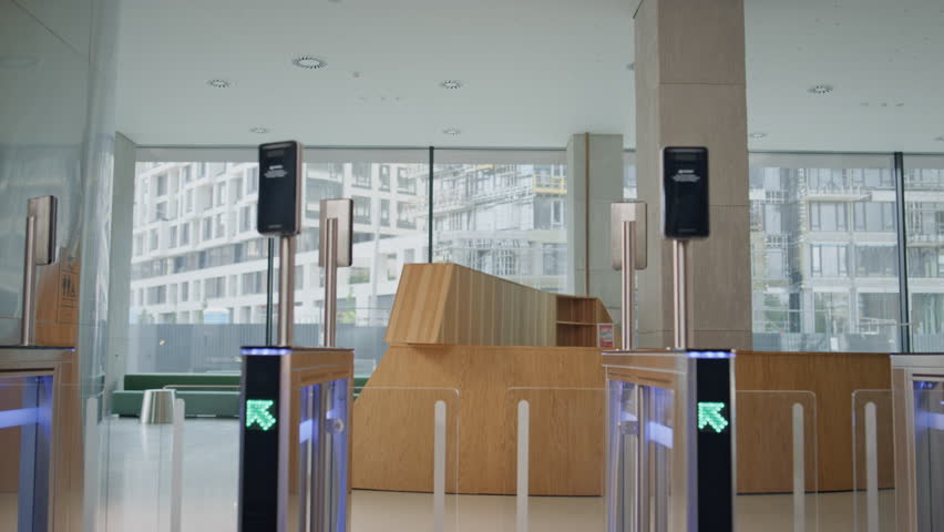 Lady boss walking turnstile office building holding coffee takeaway. Smiling successful businesswoman passing security system using card. Confident woman ceo entering in electronic gates going work.