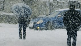 winter scene, heavy snowfall, city streets covered with snow. Houses, people and roads in winter. Blizzard, snowstorm and big snowflakes falling, slow motion. Cold weather, poor visibility - Powered by Shutterstock - Get 15% off with code: PIKWIZARD15