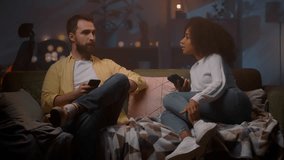 Loving couple talking with digital devices at living room. Bearded man and relaxed woman holding mobile phones at cozy sofa - Powered by Shutterstock - Get 15% off with code: PIKWIZARD15