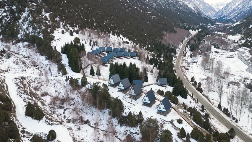 Aerial view of A Frame cabins on hill in the winter park