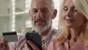 Close-up happy caucasian married couple man woman husband wife entering credit card number using phone remote paying for purchase in online store on smartphone at home use electronic banking service - Powered by Shutterstock - Get 15% off with code: PIKWIZARD15