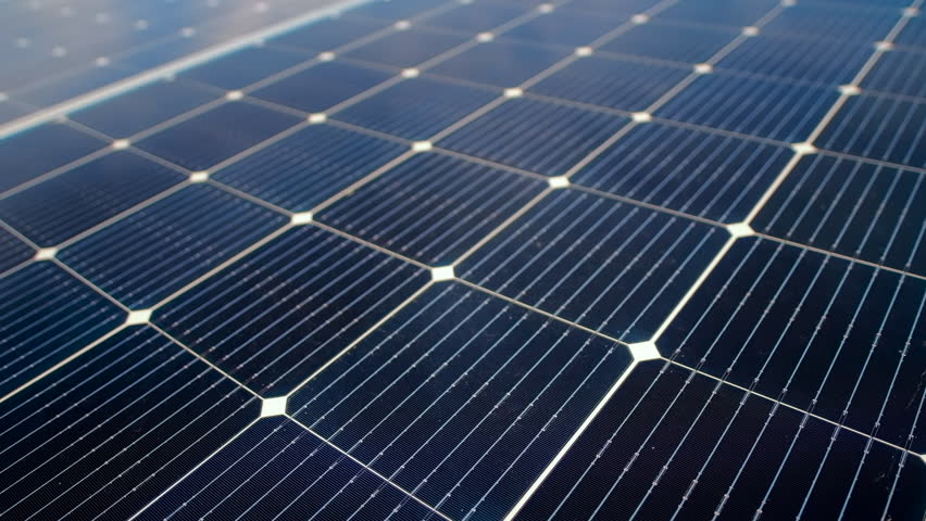 Aerial drone view of blue solar panels installed on a high efficient energy factory roof