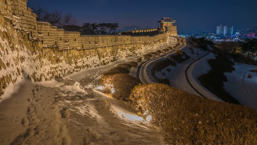 Hwaseong Fortress in Suwon at night during winter covered with snow Hwaseong Fortress is a wall surrounding the center of Suwon, South Korea.