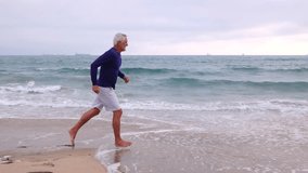 A mature 66 year old man jogging at the beach in Southern California. Slow Motion. - Powered by Shutterstock - Get 15% off with code: PIKWIZARD15