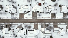 Neighborhoods in the grip of Winter weather, covered in fresh snow, aerial view.
