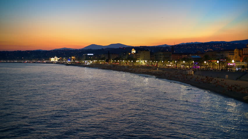 Panoramic view of Nice, France from a view point at sunset. Promenade des Anglais with illumination, classic buildings, Mediterranean sea coast