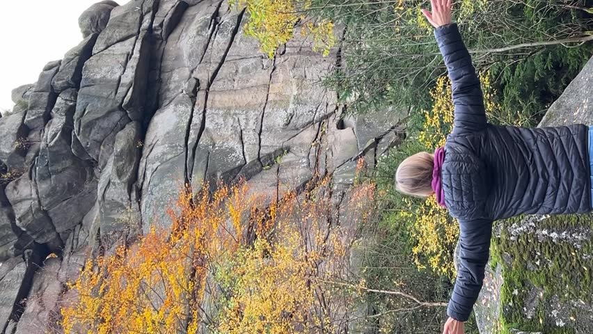 Woman enjoying nature resting in park during autumn season. Happy free girl expressing freedom. Vertical video