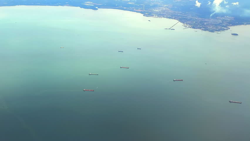 Aerial view of cargo ships off the coast of Malaysia through airliner window. Aerial view of ships parked at sea off the coast of Malaysia through plane window. Royalty-Free Stock Footage #3405588947
