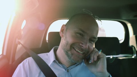 Bald Businessman Smiling While Talking on the Phone