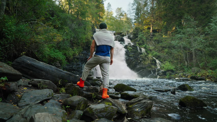 Admiring Nature In Weekend Trip, Back View Of Man Traveler Standing And Watching Beautiful Waterfall