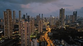 An aerial view of Mumbai's high-rise buildings and beautiful nightlights. The sky is cloudy, and there is medium traffic on the road. The cityscape is filled with modern illuminated buildings. - Powered by Shutterstock - Get 15% off with code: PIKWIZARD15