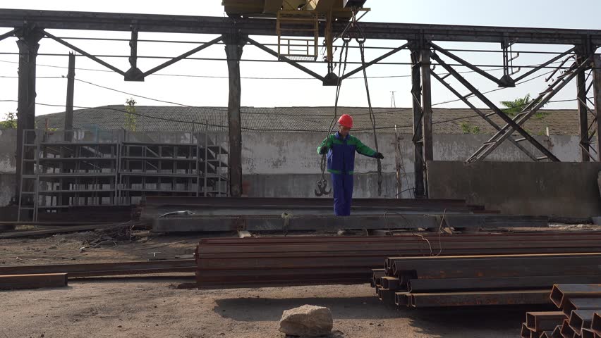 Foreman gives team a mechanical cargo crane at old factory, among metal structures and iron beams | Shutterstock HD Video #34056838