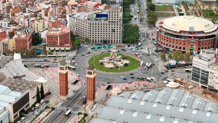 Aerial drone view of Plaza of Spain in Barcelona, Spain. Roundabout with moving cars, buildings