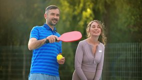 Man and woman playing pickleball in a team. Greenery on background. Outdoor court. Slow motion - Powered by Shutterstock - Get 15% off with code: PIKWIZARD15