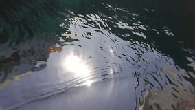 Beautiful blue sea water surface shot from sailing motor boat. Sea landscape view from moving yacht and sun reflection in water. Wide angle video footage shot with action camera.