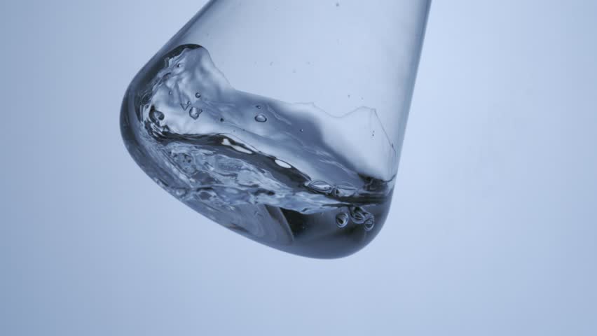 shaking glass lab ware test tube Erlenmeyer flask with water liquid in it. scientific research Skin care concept. Slow motion. 